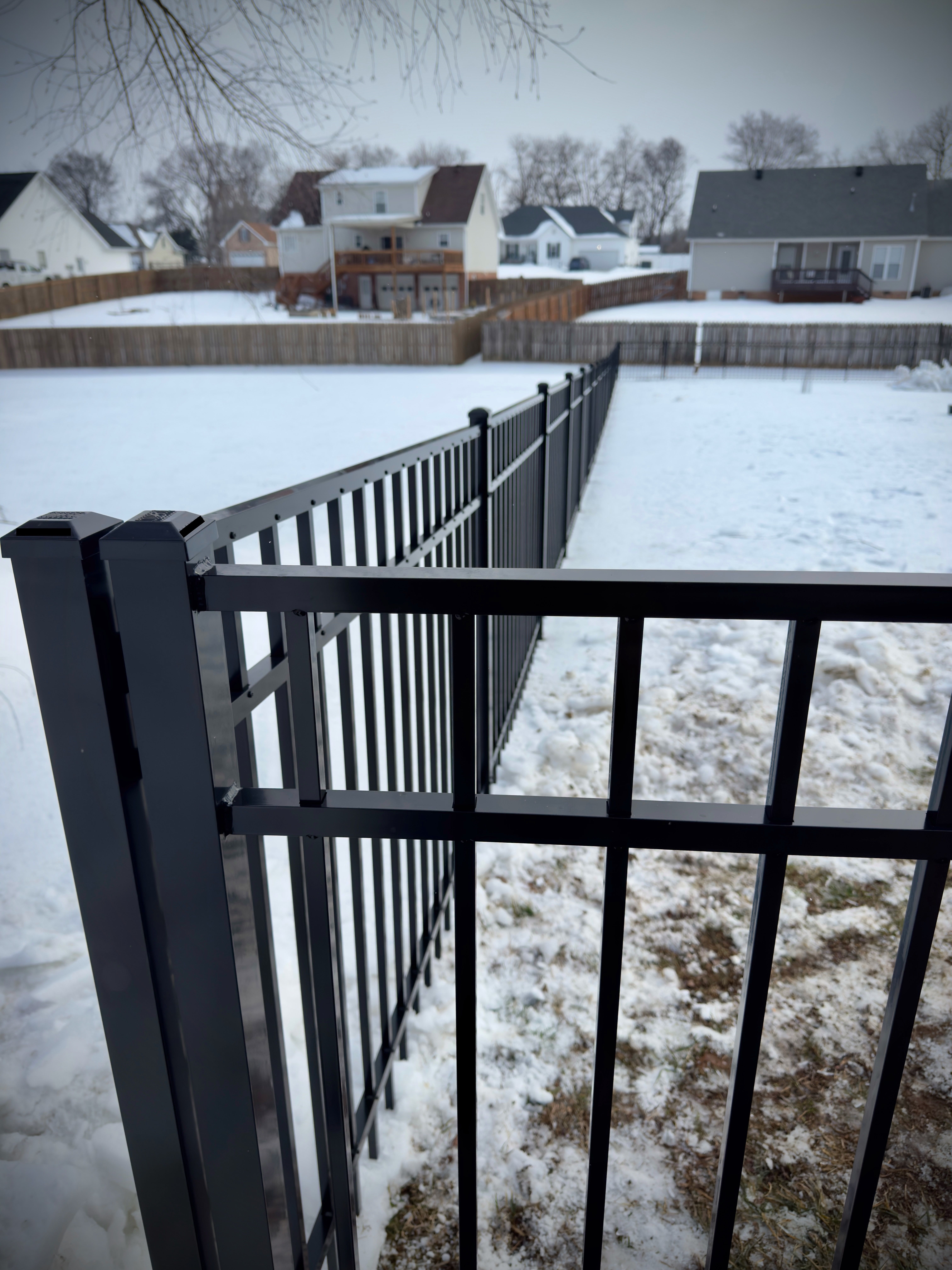 Elegant black aluminum fence installed across a sloping yard in Clarksville.