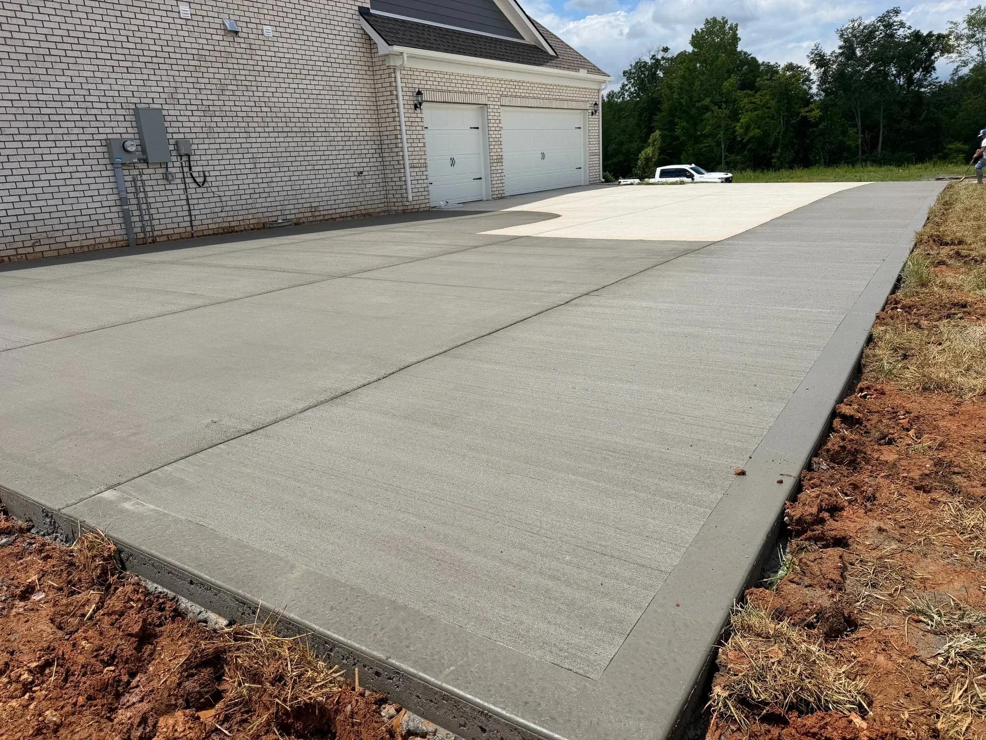 Concrete driveway extension beside a garage, showing the slab edges and joints