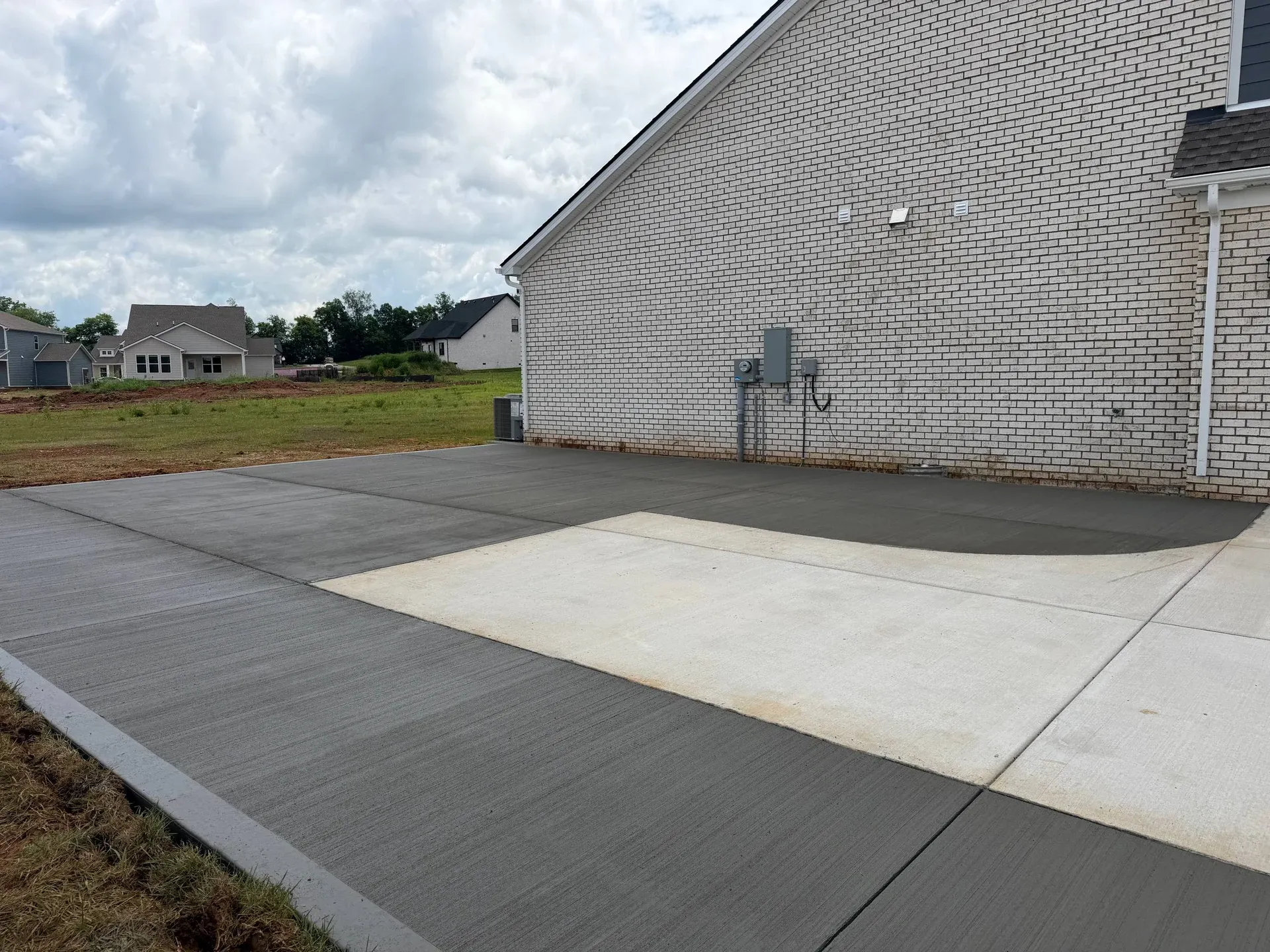 Concrete extension wrapping around the side of a garage
