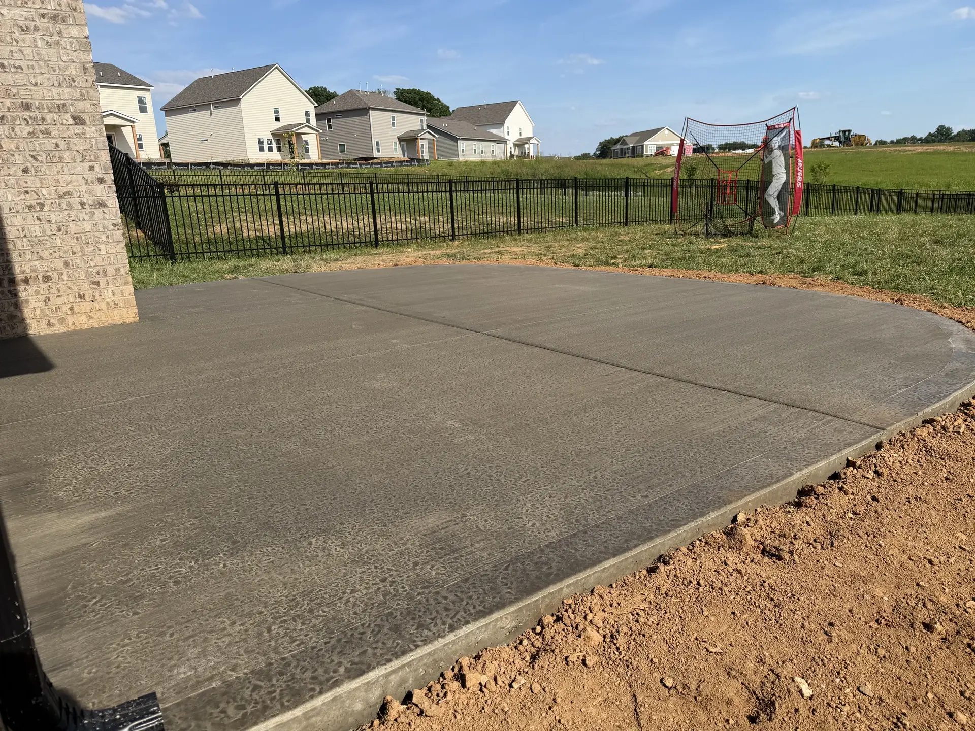 Concrete patio showing its curved edge, broom texture, and control joint
