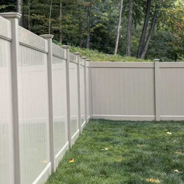 Tan vinyl privacy fence corner with a decorative upper rail